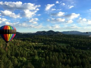 hot air balloon over mountains and trees